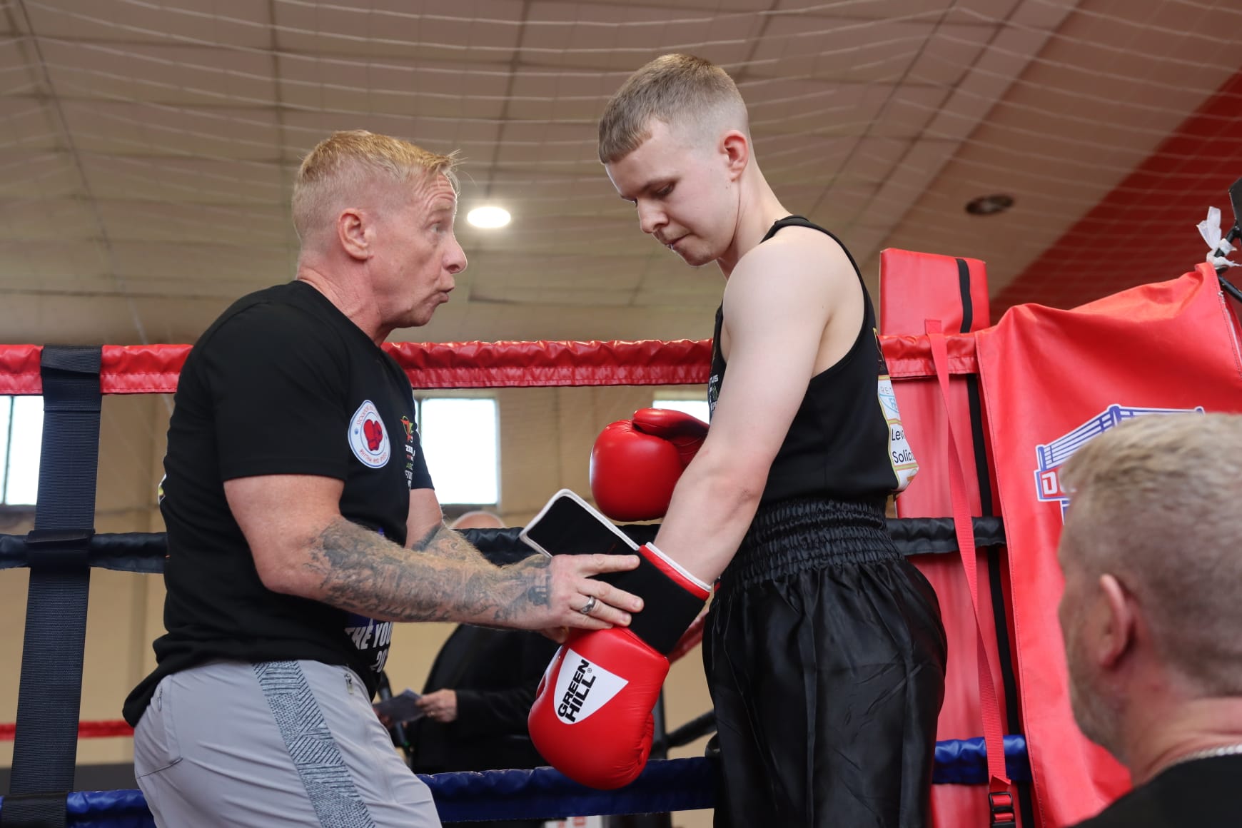A Zestus coach giving a young boxer instructions in the corner between rounds.